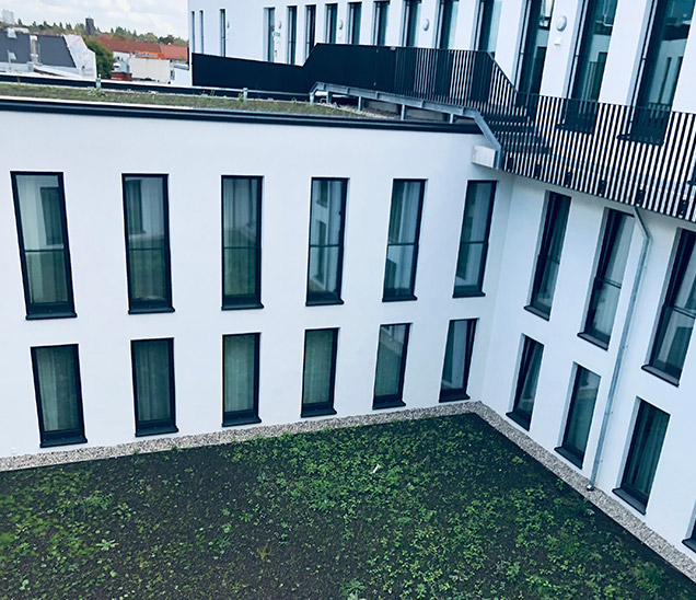 Weiße WDVS-Fassade mit Laubengang